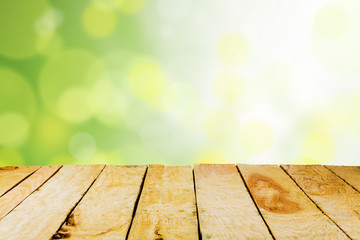 Naklejka na ściany i meble Empty wooden deck table with foliage bokeh.