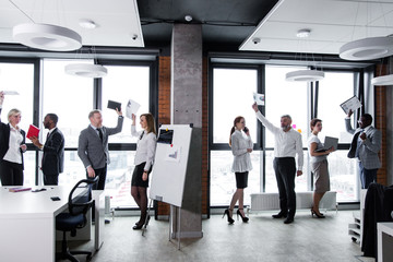 Eight business people stand on the background of a window in a modern office. Business meeting of entrepreneurs from different countries