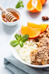 Farm cottage cheese with apple crumble or crisp served with tangerine, mint and honey. Healthy breakfast or dessert. Copy space. 