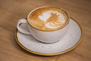 Close up coffee cup with heart latte art on table