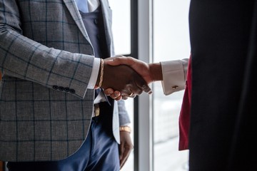 Handshake of two African businessmen in the office close-up