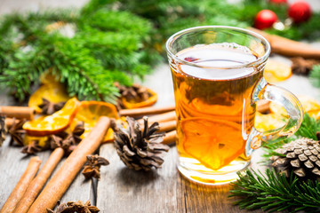 Hot tea in glass cup with atmospheric winter decorations. Selective focus. Shallow depth of field.