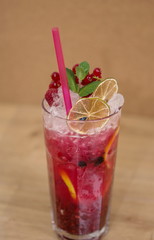 Tasty cold fresh drink lemonade with raspberry, mint, ice and lime in glass 