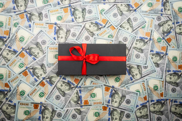 Black gift boxes with bow on background of dollars
