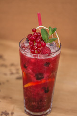 Tasty cold fresh drink lemonade with raspberry, mint, ice and lime in glass 