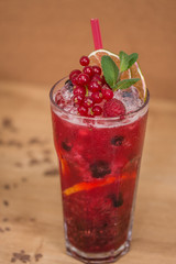 Tasty cold fresh drink lemonade with raspberry, mint, ice and lime in glass 