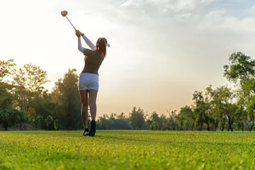 Rollo Sport Healthy. Asian sporty woman golf player doing golf swing tee off on the green sunset evening time, she presumably does exercise. Healthy and Lifestyle Concept. © freebird7977