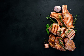 Grilled Meat. Seth meat. Grill, barbecue. On a black stone background. Top view. Free copy space.