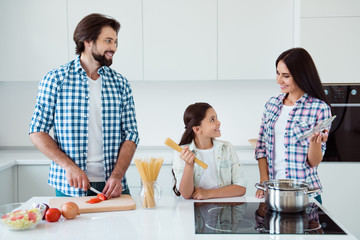 Portrait of nice lovely attractive cheerful cheery kind people mum dad pre-teen kid making fresh useful salad dish soup cuisine in light white interior indoors