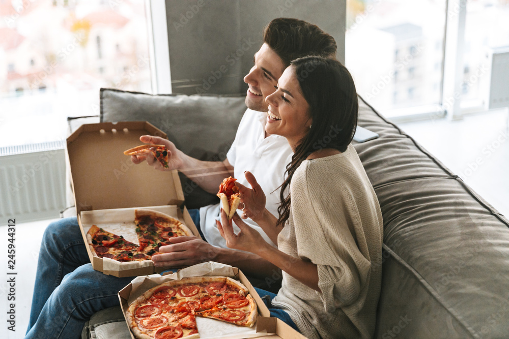 Canvas Prints cheerful young couple sitting on a couch at home