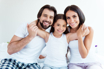 Portrait of nice cute sweet tender gentle adorable lovely attractive cheerful people sitting on bed enjoying healthy life in modern white light interior room