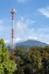 Obraz premium Telecommunications tower with antenna in forest and mountain