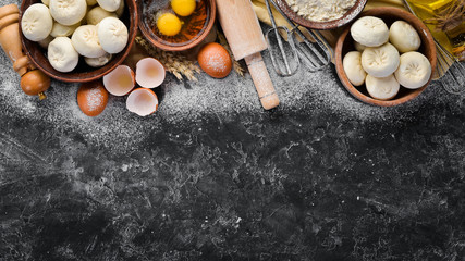 Hinkali Homemade. Flour, eggs, dough on a black background. Top view. Free copy space.