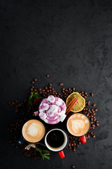 Cappuccino with milk and nuts and marshmallow. On a black stone background. Top view. Free copy space.