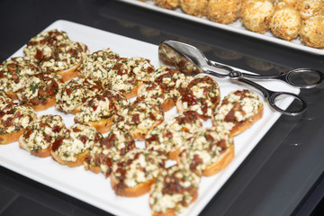 Tongs-tongs lie on a tray of sandwiches