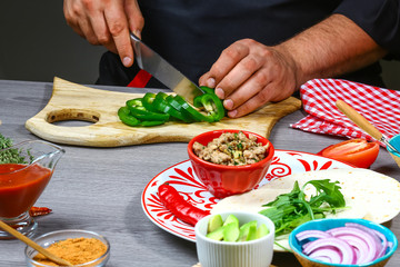 Cooking Mexican taco with meat beans and vegetables. Latin american food background