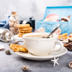 Cup of coffee and biscuits with seashells and decorations. Dreams of sea vacation and concept