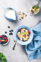 Healthy food background with homemade oatmeal granola or muesli with yogurt and fresh berries for...