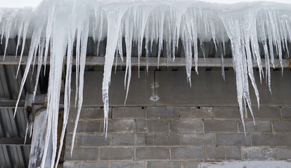 big icicles overhanging on a roof