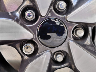 Shiny high performance tire with chrome iron wheel locking nuts. Security locks for automobile...