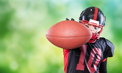 American football player with the ball isolated on a dark