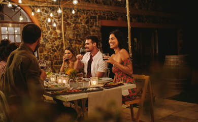 Group of friends having wine at dinner party