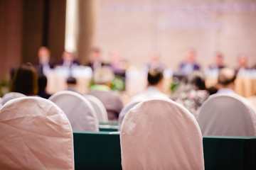 White fabric chair with blurry of auditorium for shareholders' meeting