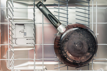 Dirty frying pan lies in the dishwasher
