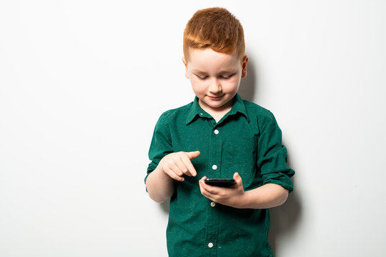 Conceptual photo of a boy texting on his cell phone in a studio