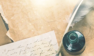 White feather quill pen, glass inkwell and old letter