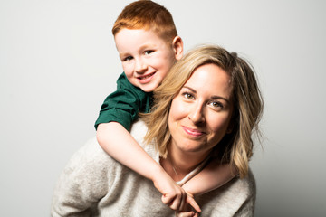 A happy young mother with a child on light grey background