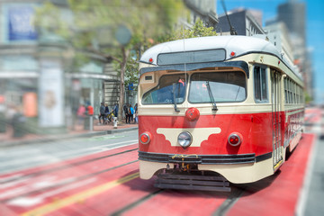 Fototapeta na wymiar Famous red streetcar tram speeding up in Market Street, San Francisco, CA