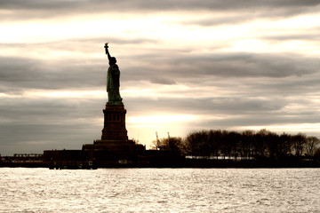 Silhouette of Statue of Liberty against sunset sky