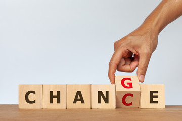 Hand flip wooden cube with the word CHANGE to CHANCE on white background. Concept of personal development