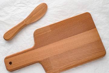 Wooden cutting board and wooden knife on a white background. Kitchenware