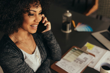 Female architect talking with client over phone