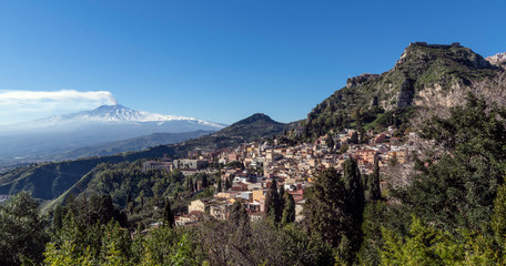 Fototapeta na wymiar City of Taormina in Sicily. In background smoking volcano Etna