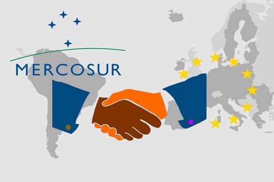 Trade agreement between Mercosur and the EU -   On the maps of South America and Europe are the respective symbols. In front of it the illustration of a handshake as a symbol for a contract.