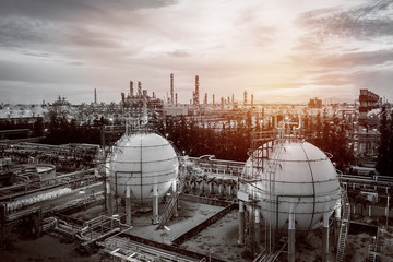 Gas storage sphere tanks and pipeline in oil and gas refinery industrial plant on sky sunset...