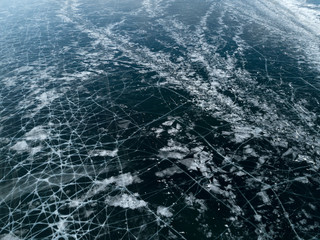 View of the frozen Lake Baikal in winter from drone. Ice cracks on lake. Abraham Lake, Lake Superior. Cracked ground of frozen lake Baikal, Irkutsk, Siberia, Russia. Slippy and cold frozen ground.