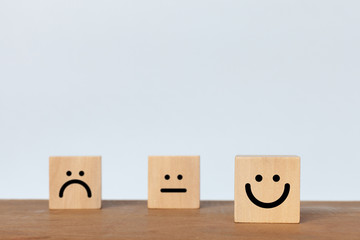 Smiley face wood cube on white background. Service rating, satisfaction concept