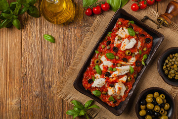 Cod in Italian in tomatoes with olives and capers.