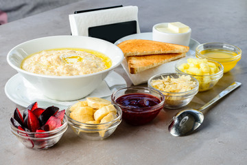 Healthy English breakfast. Sweet oatmeal porridge with different fruits and jam