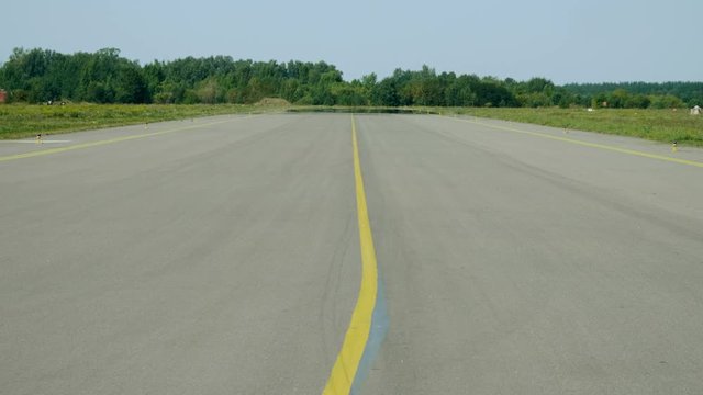 Medium shot of empty runway of airport in summer. 4K