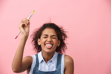 Beautiful young african woman atrist holding a paint brush