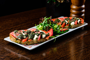 Tasty dish in a restaurant. Slice of bread served with fresh tomatoes and cheese