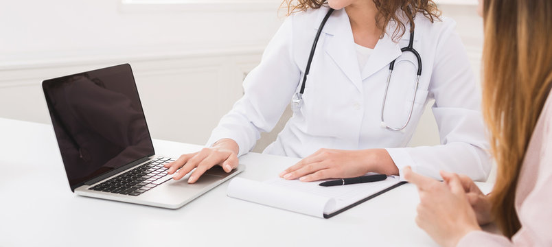 Doctor using laptop in office, making patient's anamnesis