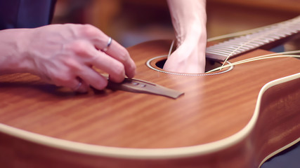 Guitar repair, man changes the strings