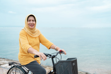 happy senior muslim female riding a bicycle