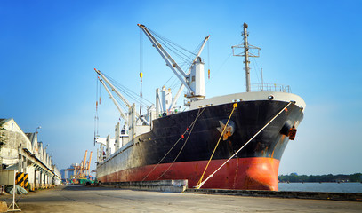 Container ship in export and import business and logistics. Shipping cargo to harbor by crane. Water transport International. 